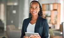Smiling woman holding tablet in office