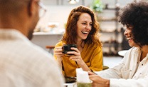 Friends smiling while enjoying coffee