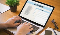 Patient filling out dental insurance form on computer