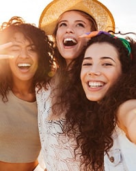 Three friends posing for a picture at the beach