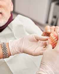 A dentist showing dentures to their patient