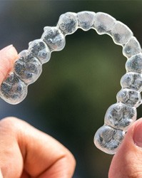 a person holding Invisalign trays